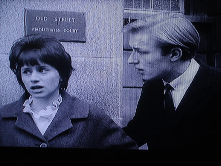 the woman is wearing a suit in front of a man in an elevator