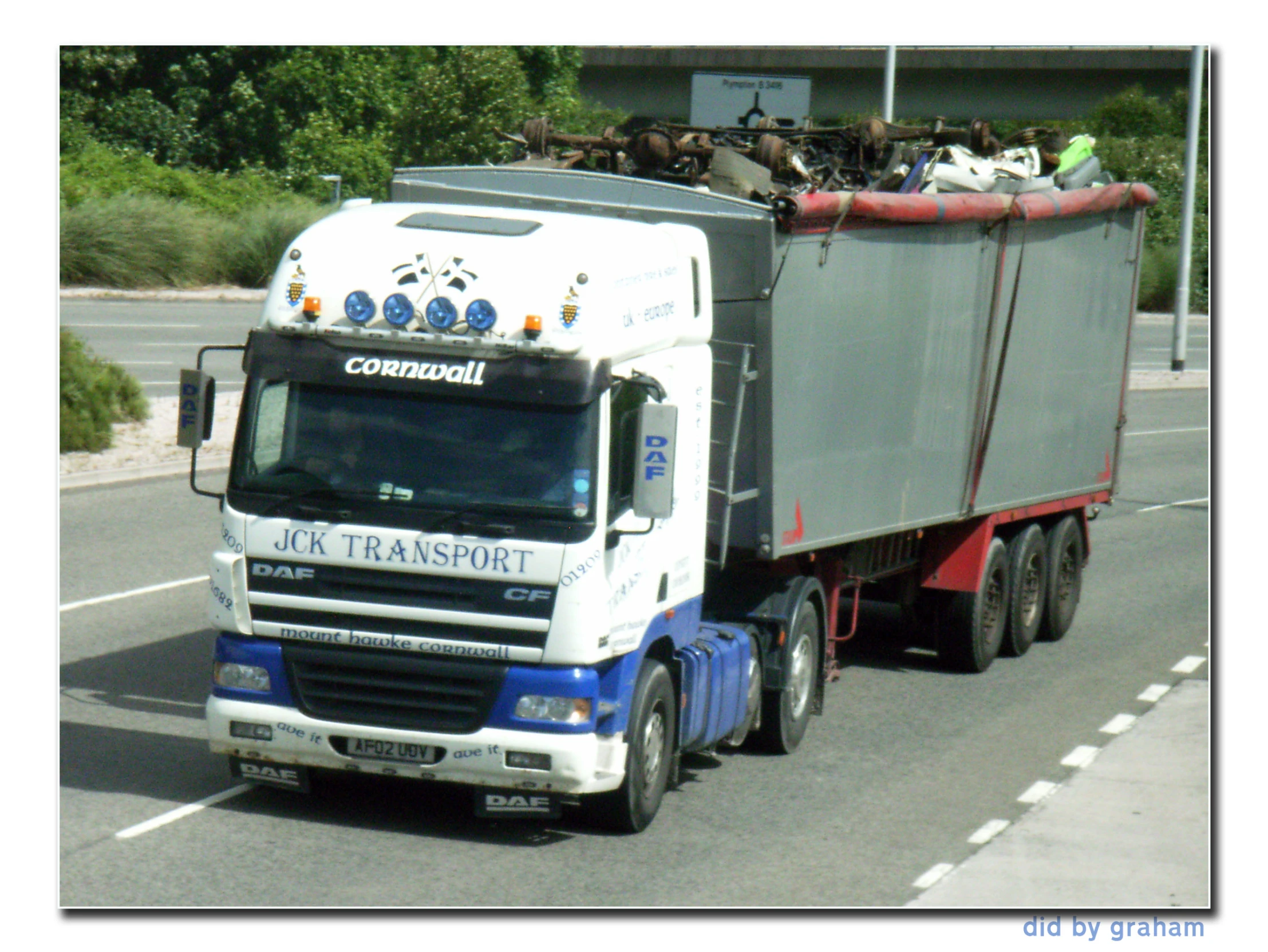 a tractor trailer with containers on the front driving down a road