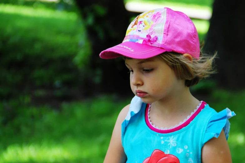 a girl wearing a little red hat in the park