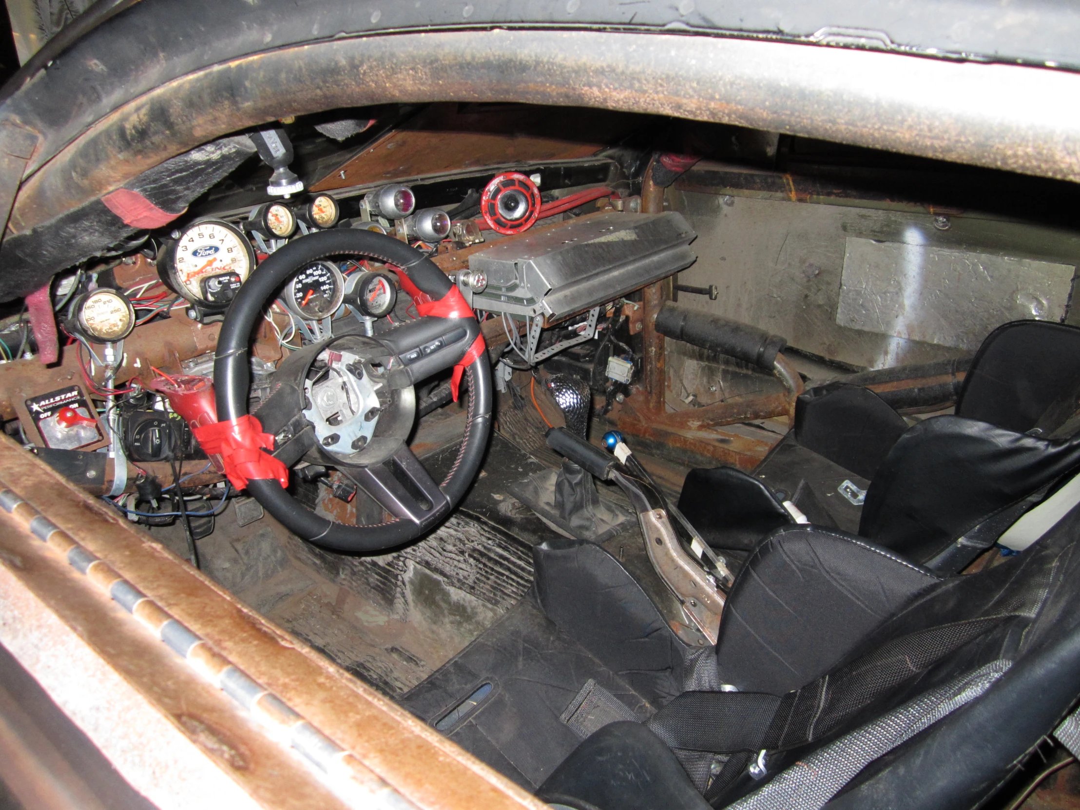 the dashboard in an old dirty car, showing its old parts and repair supplies