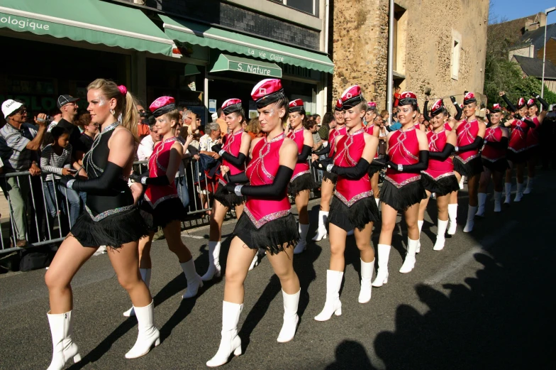 there are many women in pink dresses and black hats