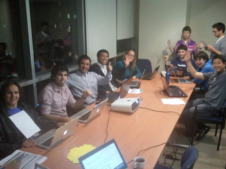 a group of people in a boardroom talking and laughing