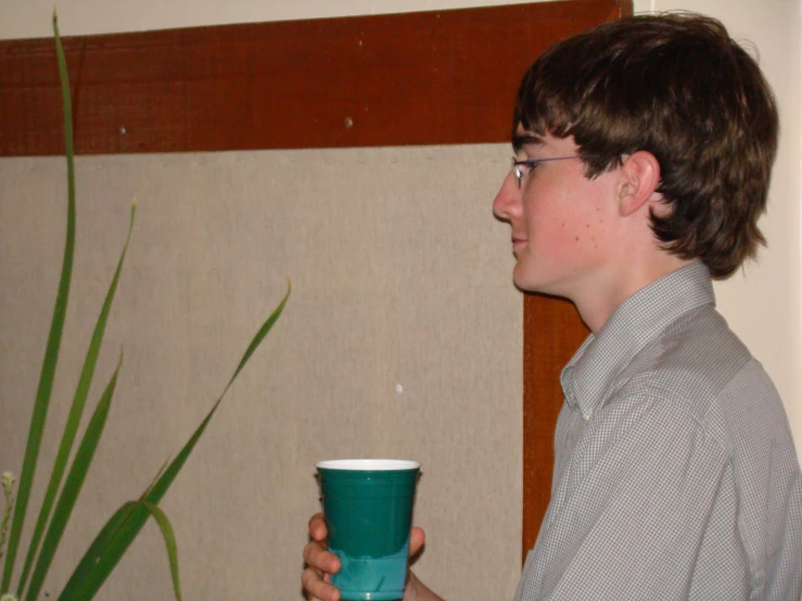 a young man holding a cup in his hands