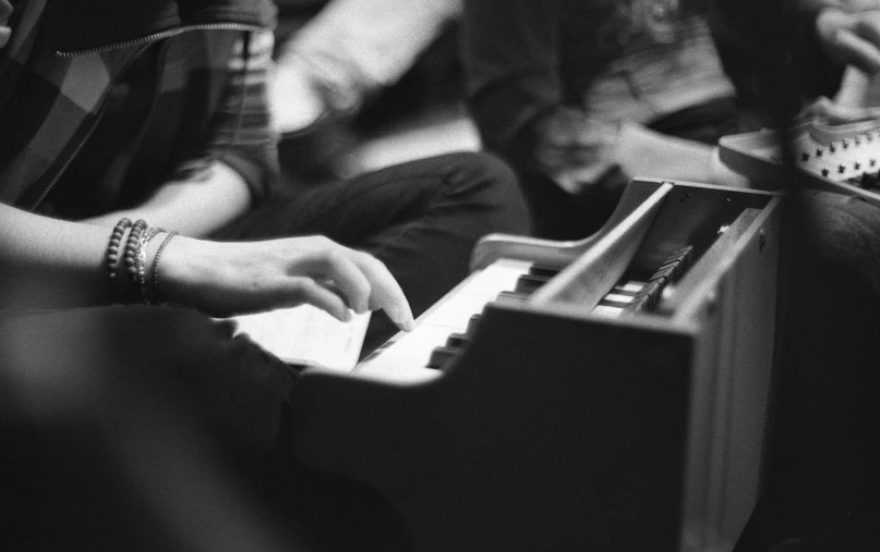 black and white pograph of a person's hands playing a piano