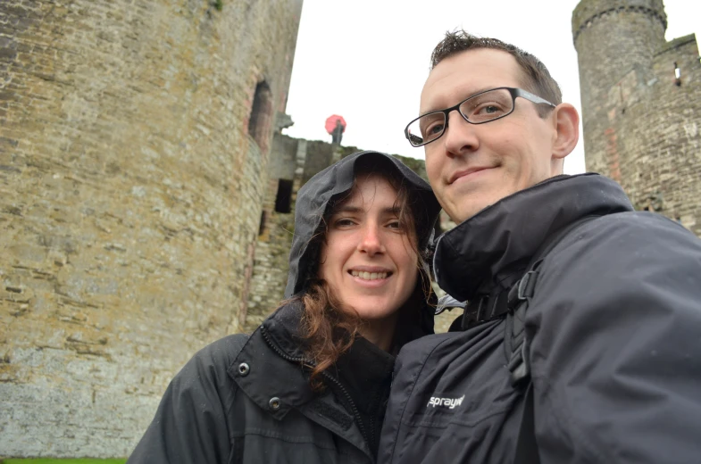 two people are outside in front of a castle