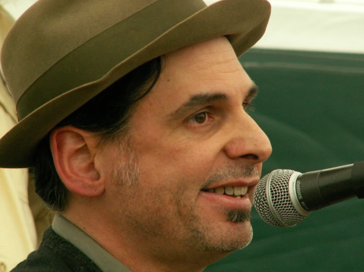 the man is talking into a microphone at a public event