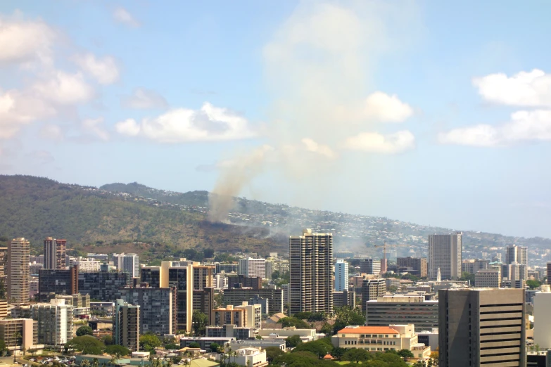 smoke billows out from the skyline and buildings on the hillside