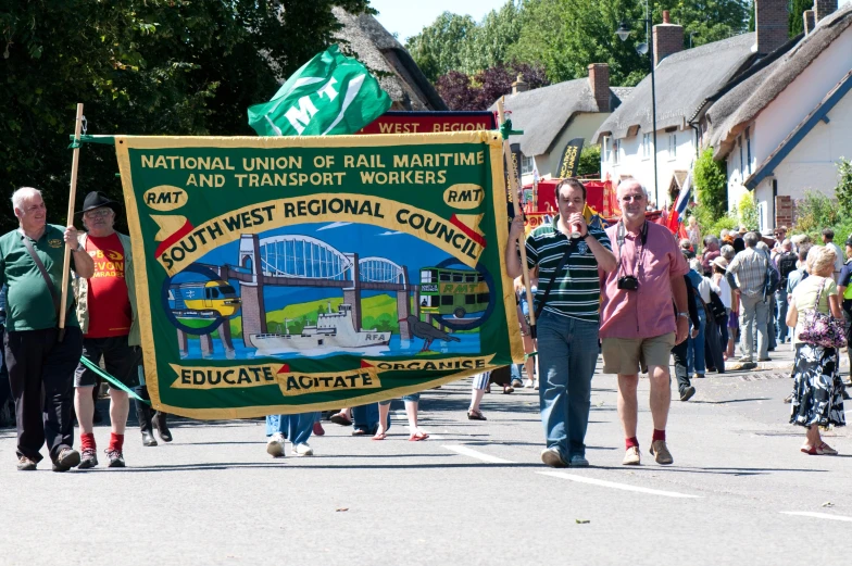 people are walking in the road carrying banners