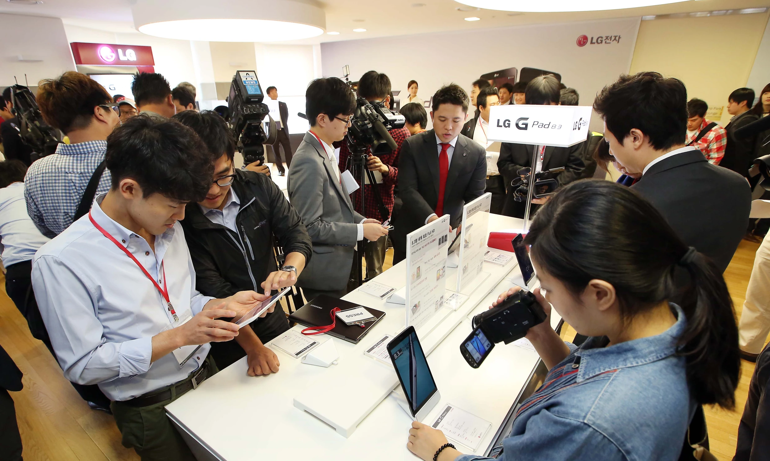 people are standing around at a trade show and looking at cell phones