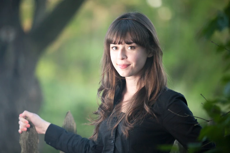 a woman is standing in the woods holding a hand