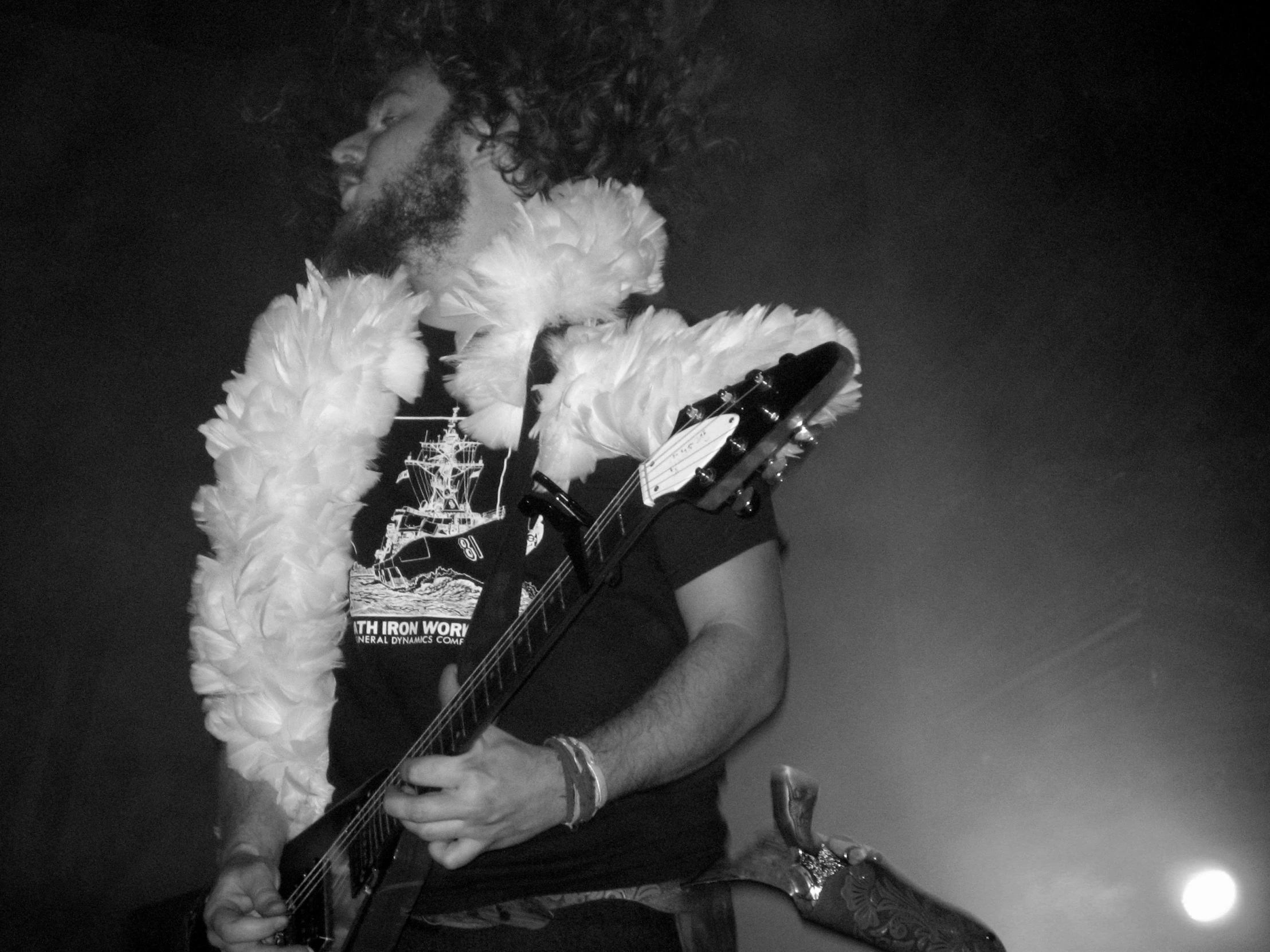 a man with a very big feathered headdress holding a guitar