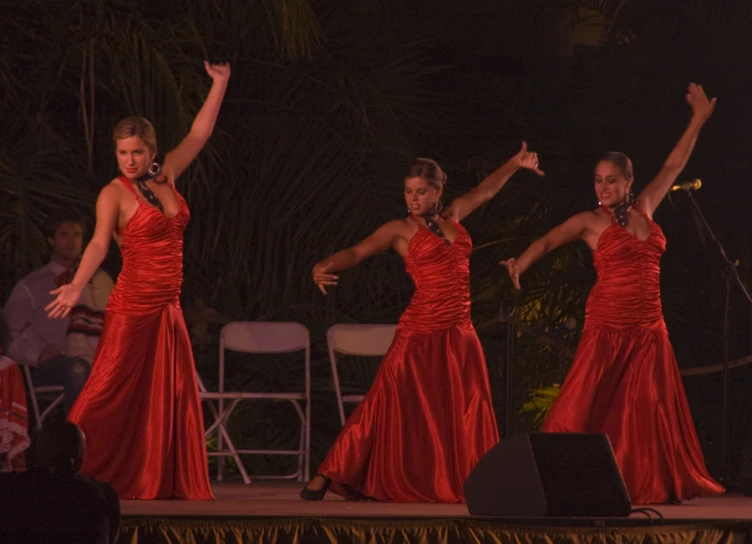 three women in red dresses performing at a party