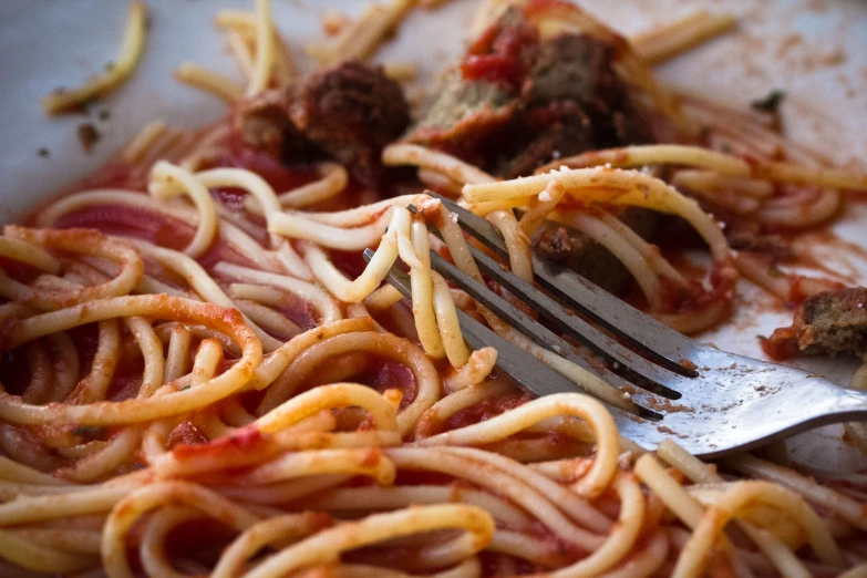 a fork that is in some spaghetti