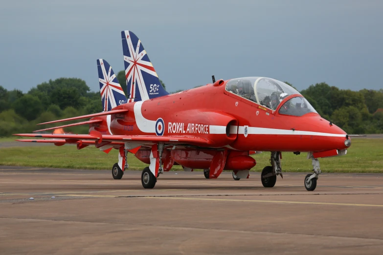 an airplane sits on the tarmac with british flags flying in the background
