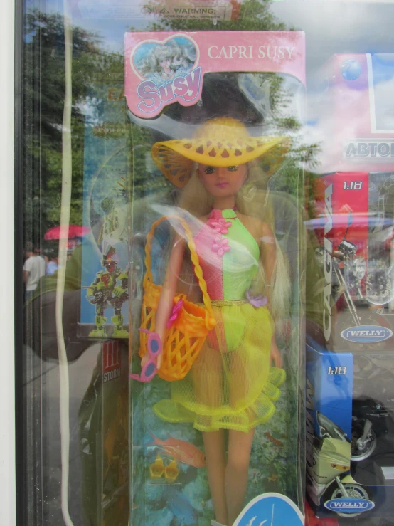 a barbie doll in a yellow outfit and hat holding a purse