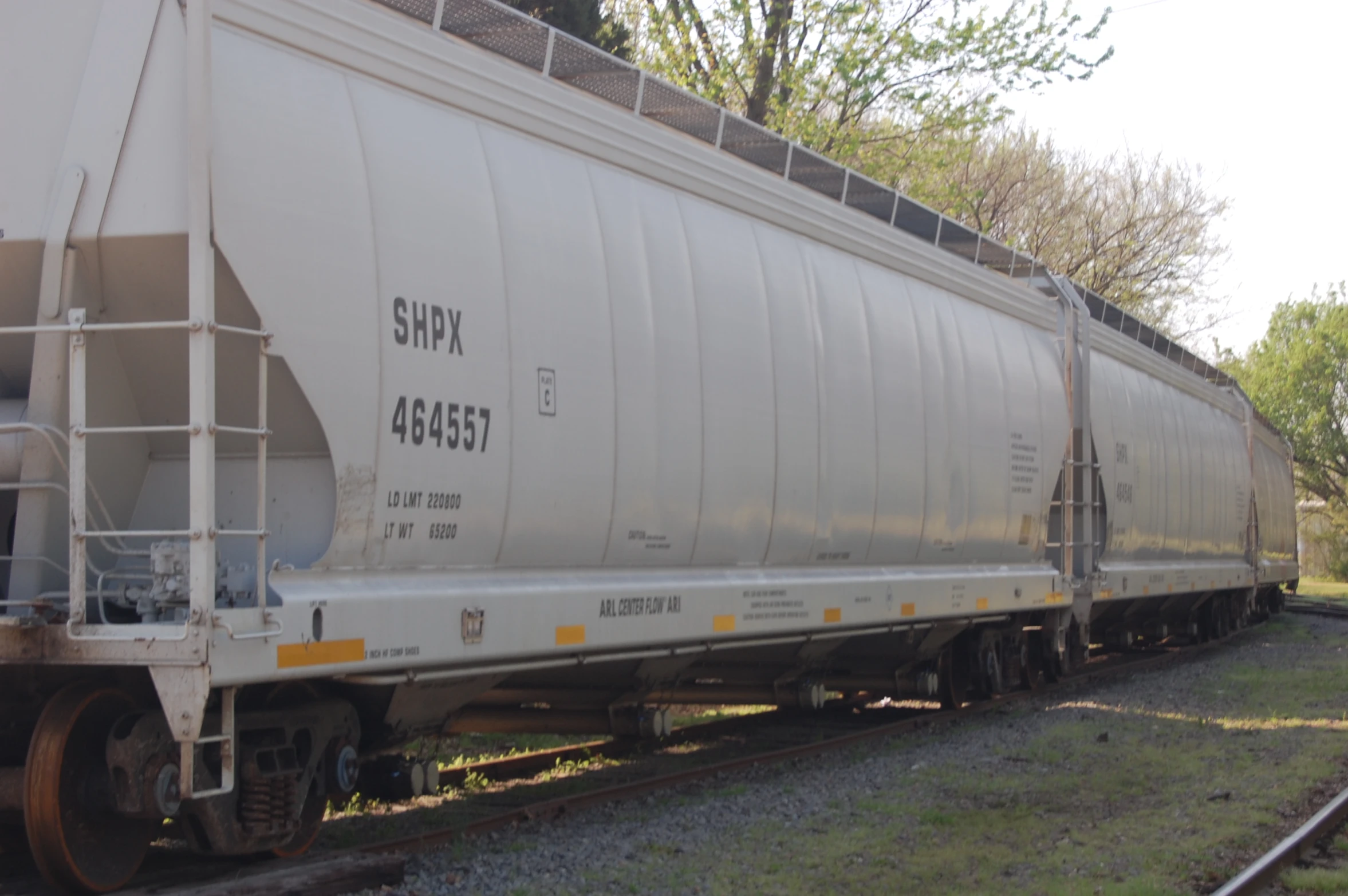 a long train car parked on the side of the track