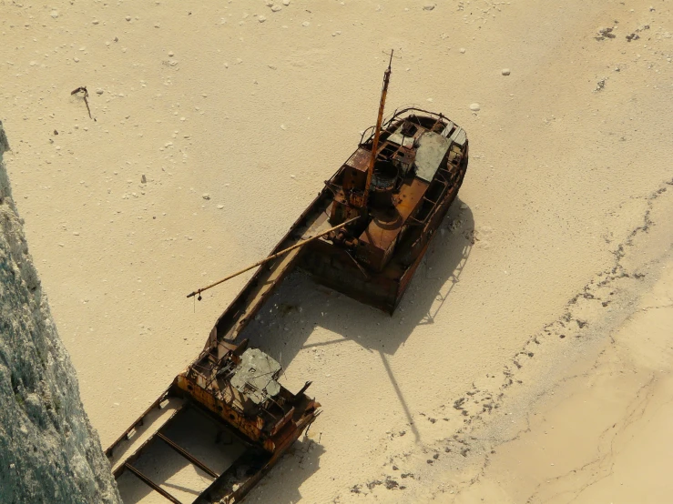 a small wooden ship that has been pulled into the sand