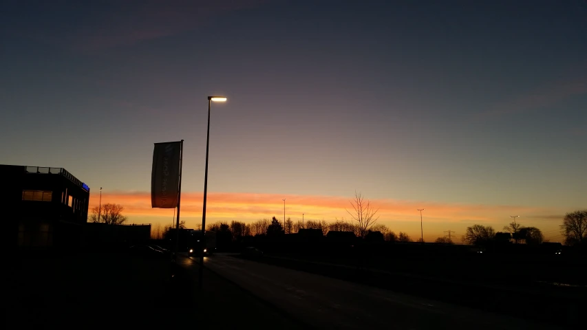 the sunset is shining brightly over the street light