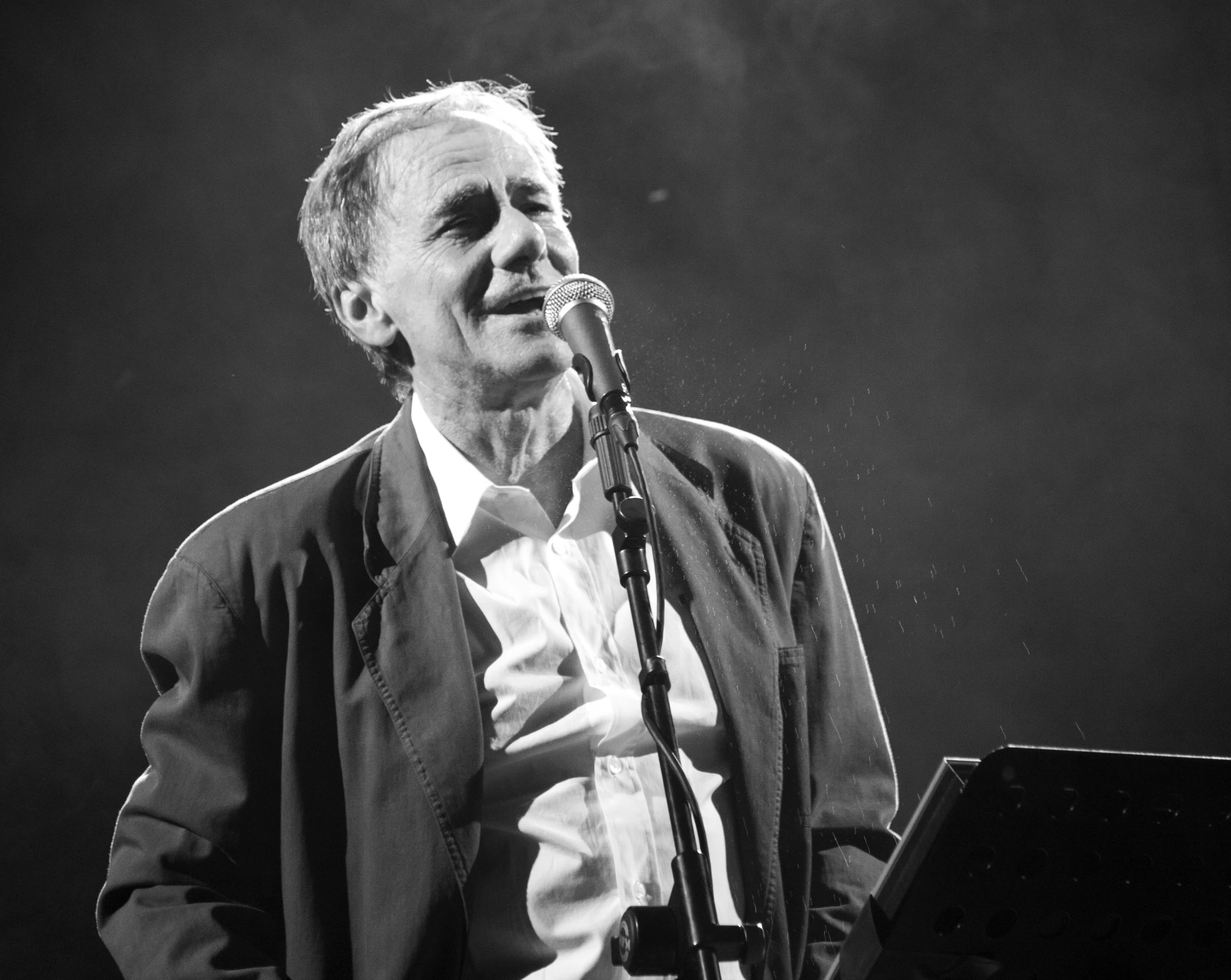 a man in a suit sings into a microphone