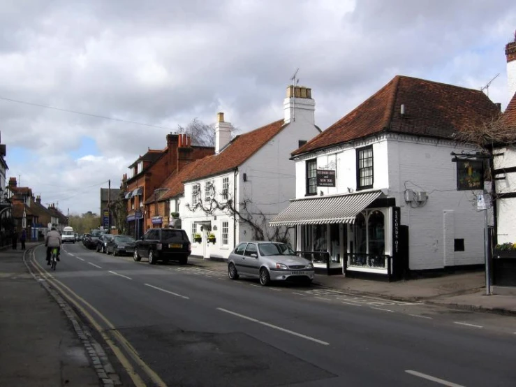 an older street with a store with cars parked on the side of it