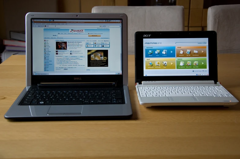 a table topped with two laptop computers next to each other