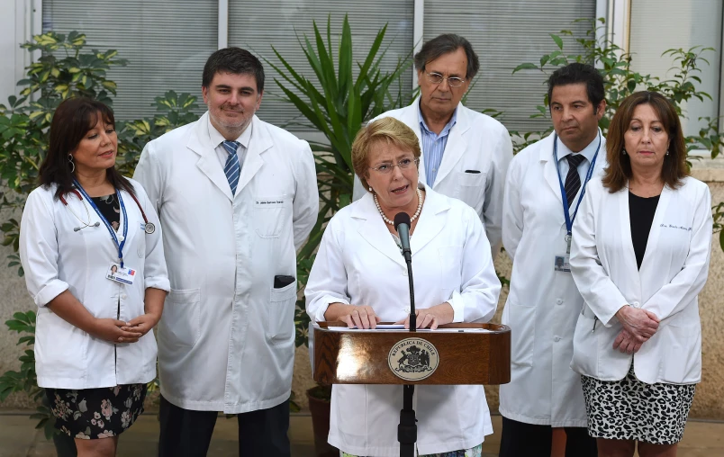 a group of doctors standing around a podium