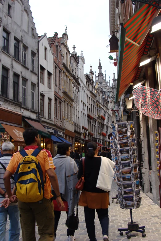 people with large luggage walking through the crowded street