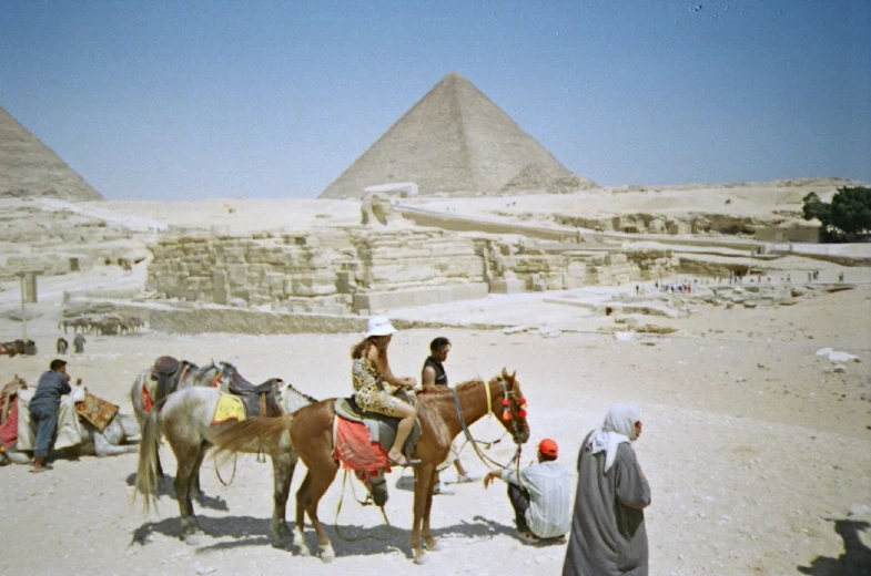 an old po of some people and horses in front of the pyramids