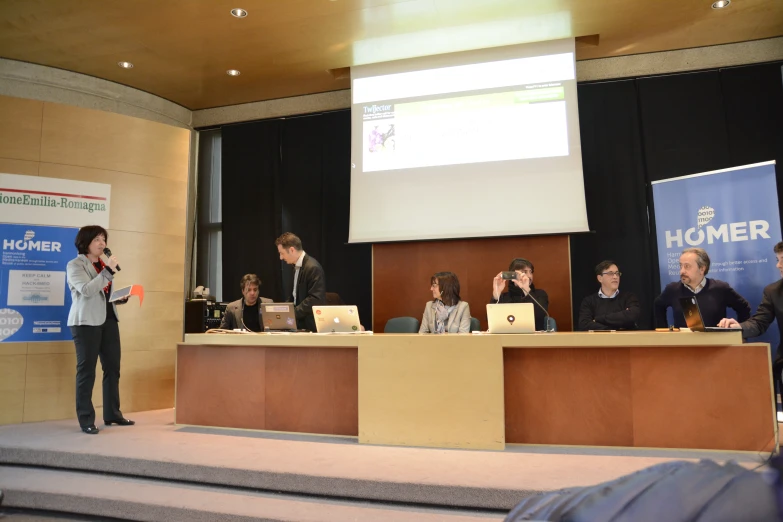 a group of people are speaking and being presented on a stage