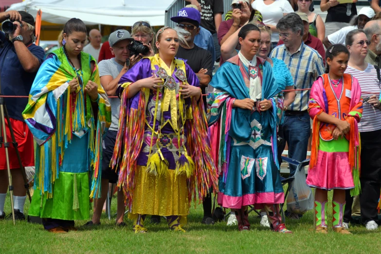 young people dressed up as colorfully dressed performers in front of a crowd