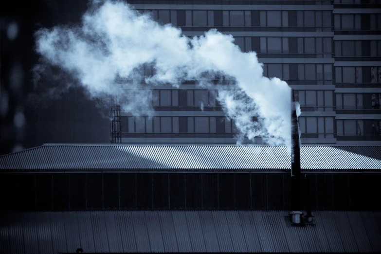 smoke coming out of a chimney in a city