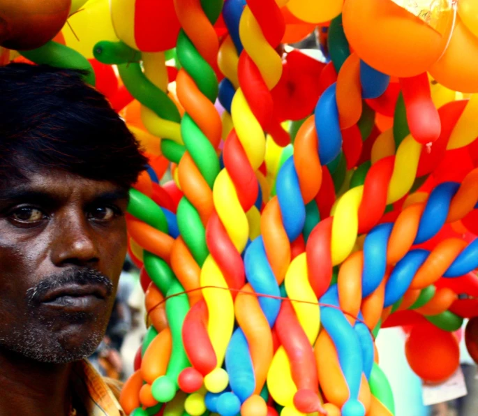 a man standing under a bunch of balloons