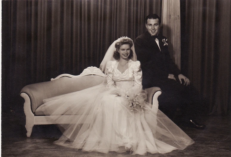 a vintage pograph of a woman sitting next to a man in a tuxedo and gown