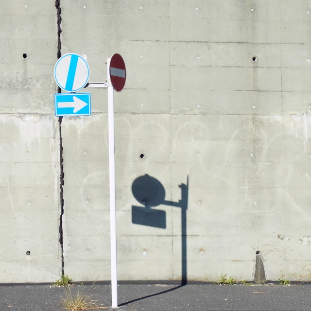 a traffic sign in front of a large concrete wall