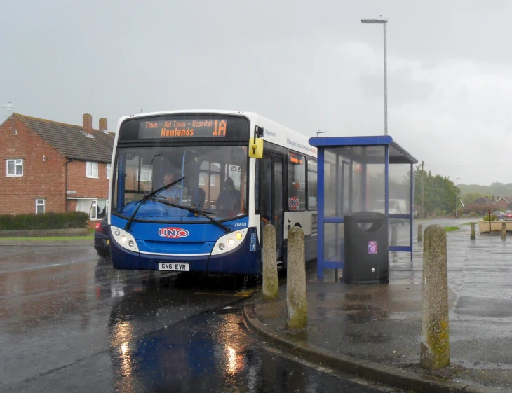 a blue bus is stopped at a bus stop