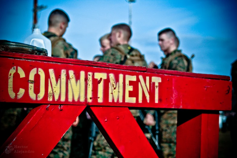 three soldiers standing behind a red barrier