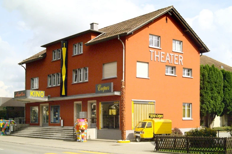 an orange building with a bunch of people in front