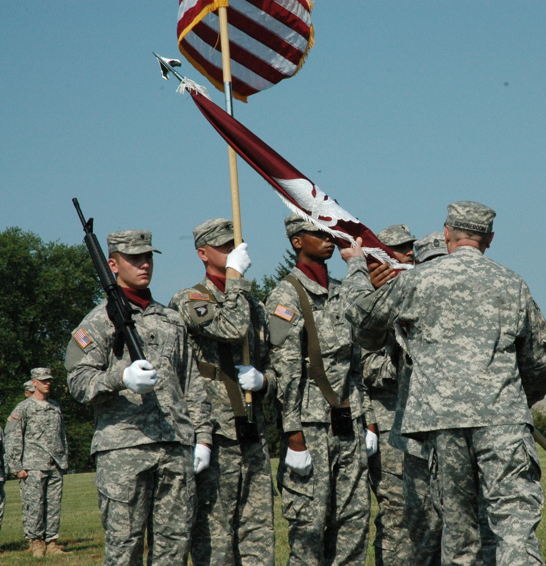 several army soldiers from the army standing around and holding a flag