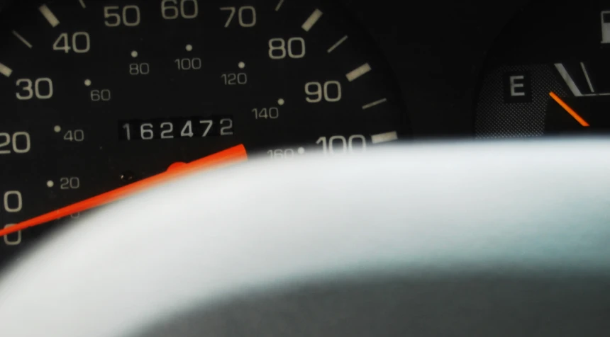 a car dashboard with a gauge and some orange arrows