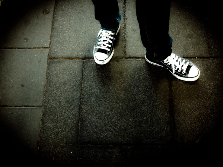 black and white shoes in shadow of person's legs