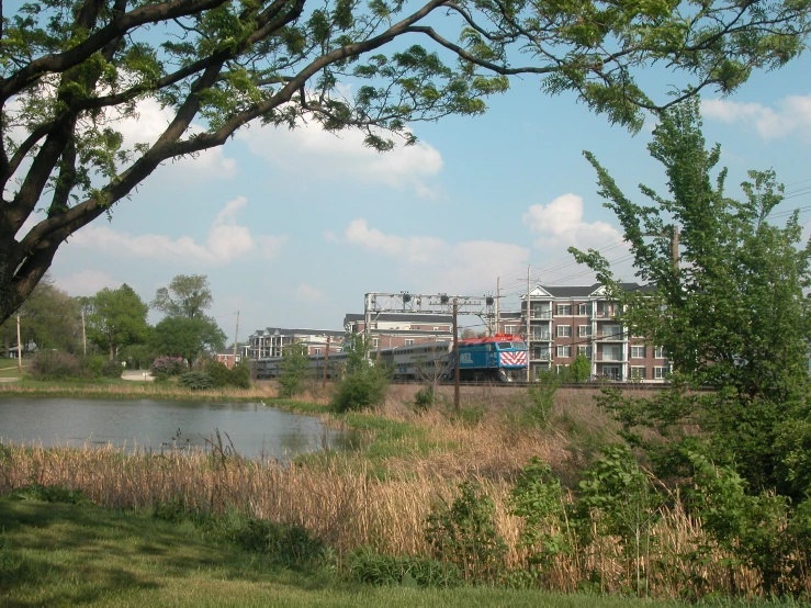 a water way and river next to trees, with several buildings in the background