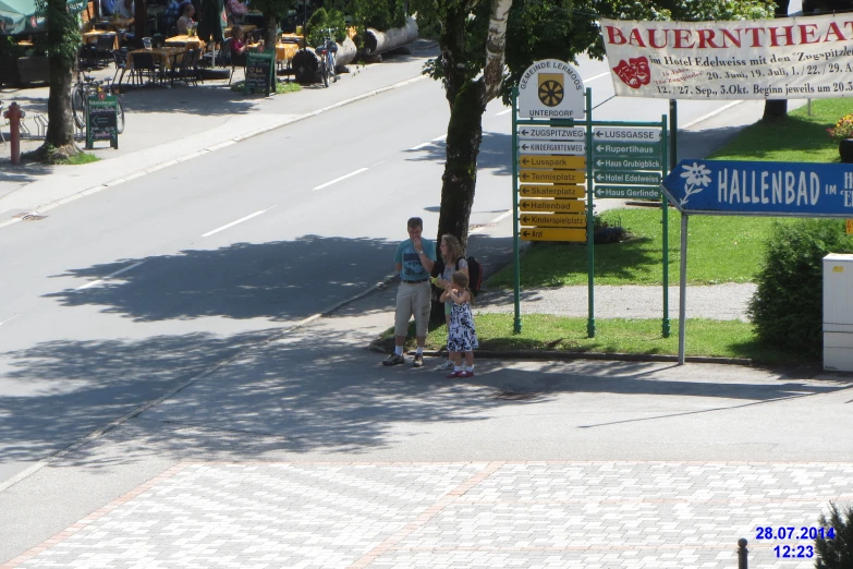 three people standing on the side of a road