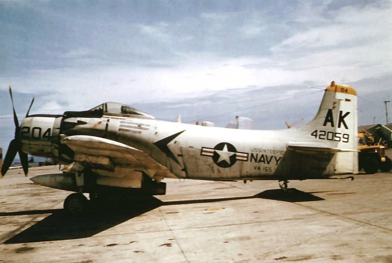 an old war plane parked on the cement