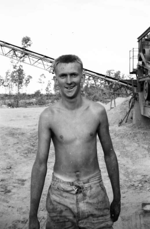 a black and white po shows a man without shirt, and is smiling