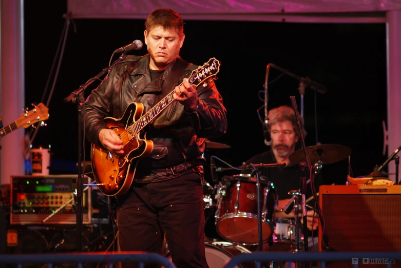 two people play instruments in a music venue