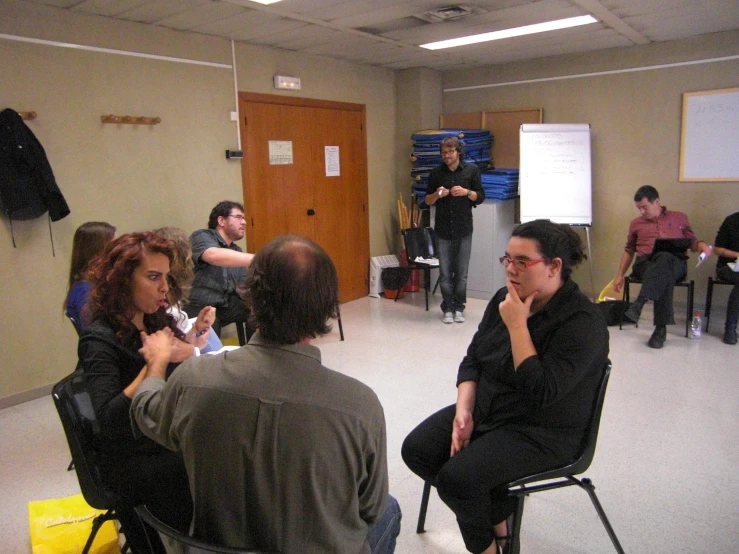 a group of people sitting in chairs talking