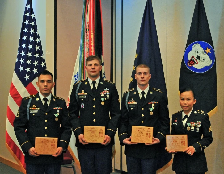 young members of the army's national rifle and pistol association are holding plaques at their desks