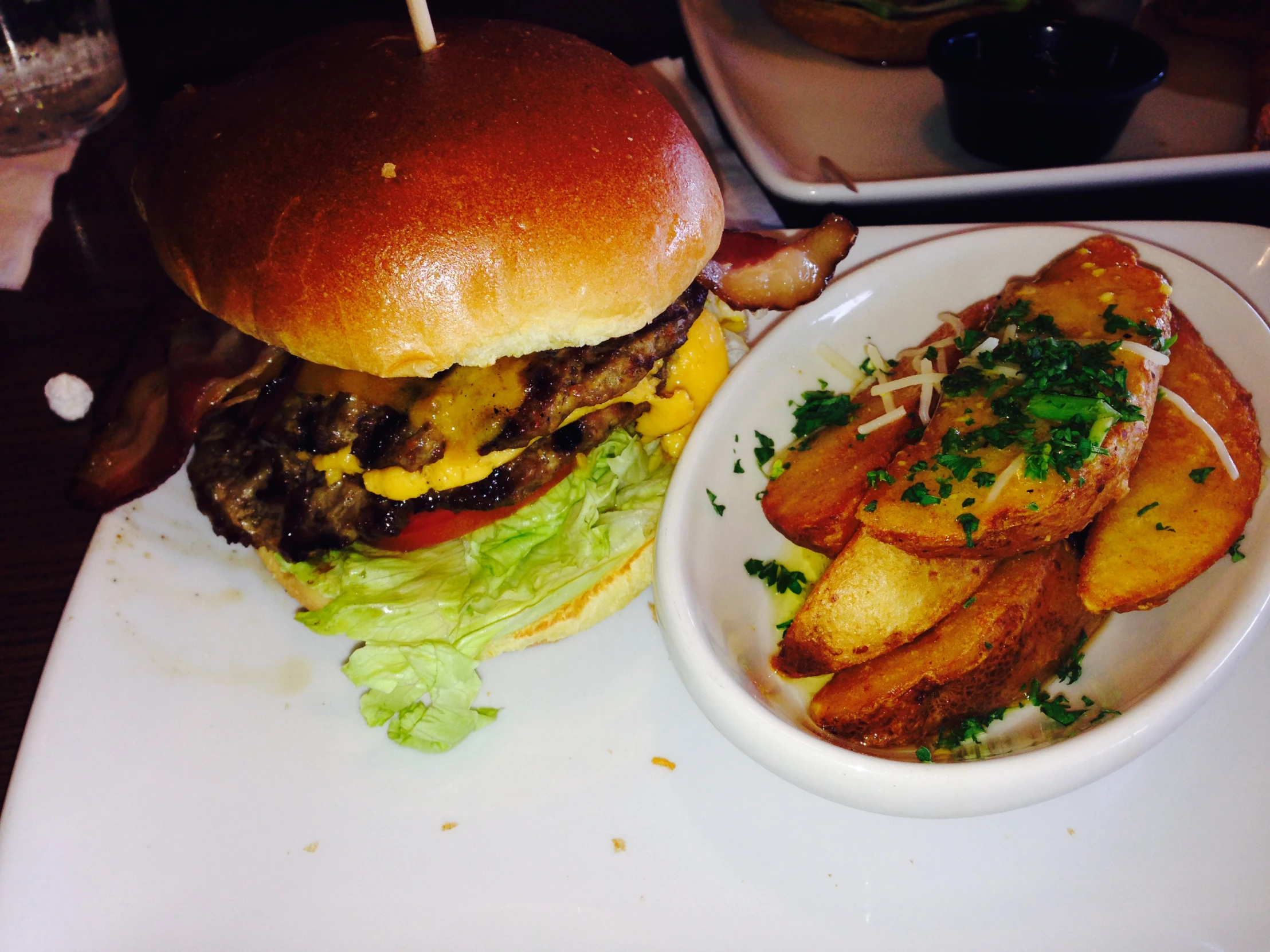 some french fries and a large hamburger on a white plate