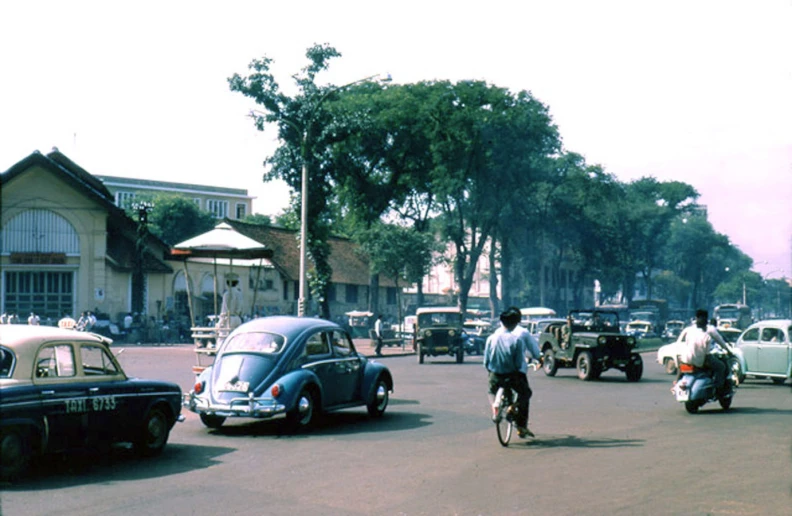 a person riding a bike next to vehicles and a car