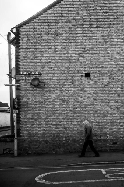 a black and white image of a person walking on a street